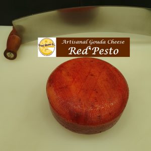 Small artisan raw milk baby Gouda red pesto cheese with red pesto herbs (chili, pepper, basil, garlic, oregano leaf, and paprika) with a cheese wheel weight of ±1 kg